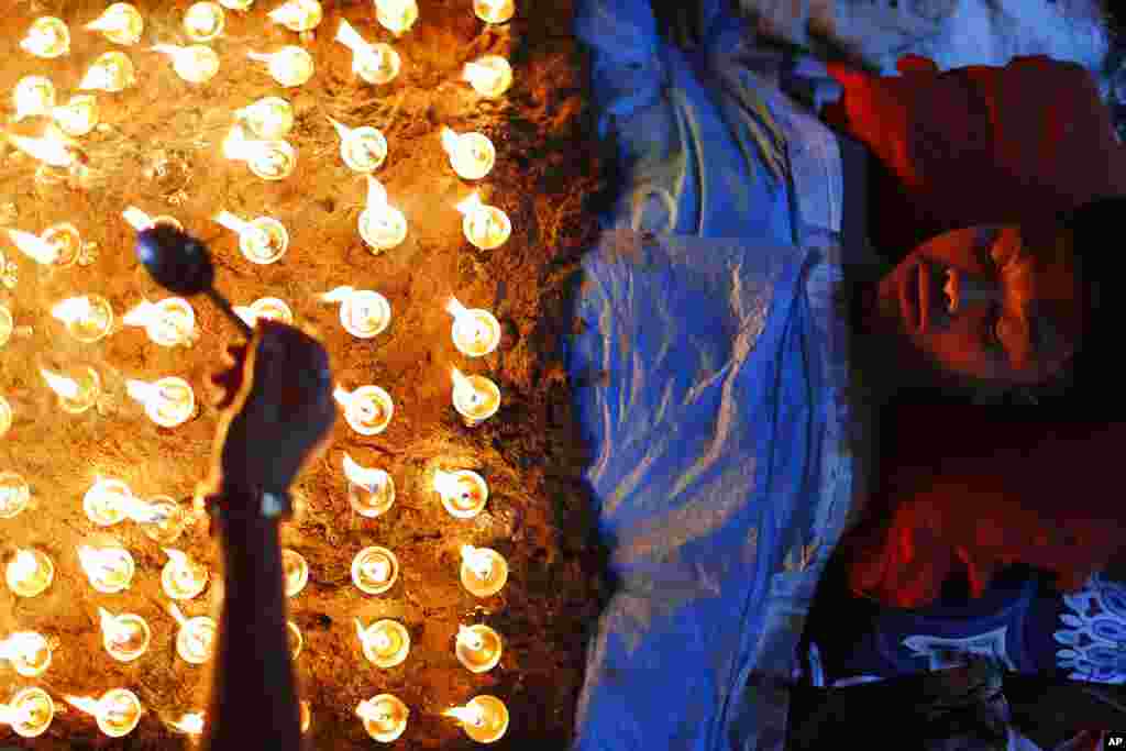 A man lies still as devotees light oil lamps over his body as part of rituals to celebrate the tenth and final day of Dashain festival in Bhaktapur, Nepal.