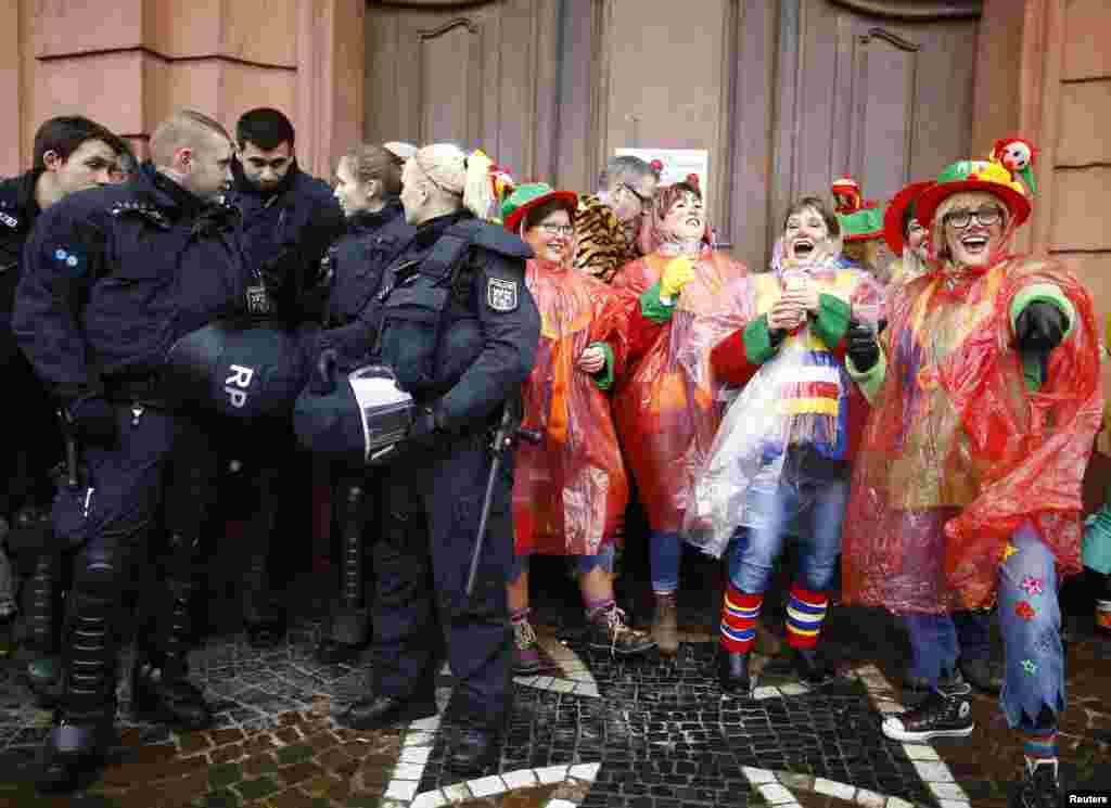 Polisi berpatroli sementara para orang-orang ikut karnaval &quot;Weiberfastnacht&quot; (Karnaval Perempuan) di Mainz, Jerman.