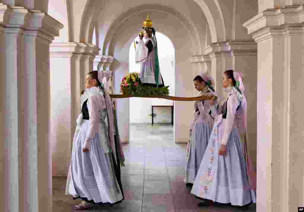 Women dressed in the traditional clothes of the Sorbs carry the statue of Virgin Mary during a procession in the church in Rosenthal, Germany.