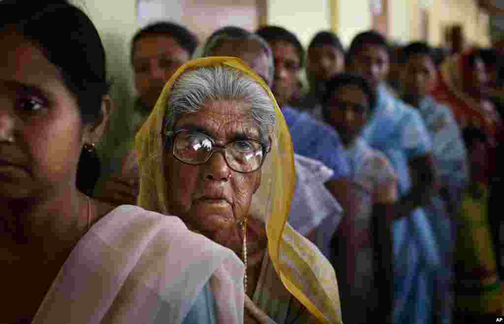 Uma mulher idosa na fila para votar observa o processo da primeira fase das eleições em Dibrugarh, no nordeste do Estado de Assam, Índia, Abril 7, 2014.