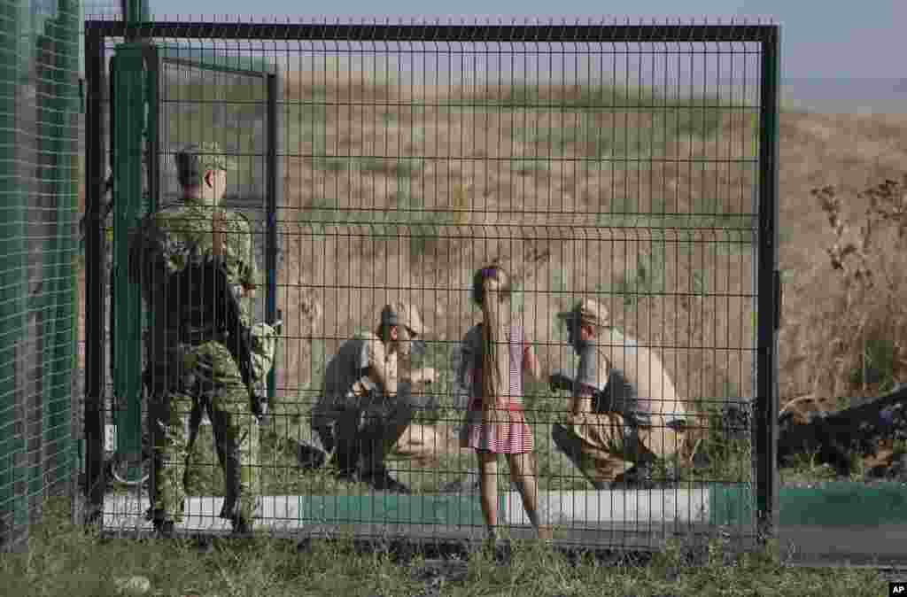 Truck drivers from the Russian aid convoy take a break in the Russian inspection zone, inside a border control point with Ukraine, Donetsk, Rostov-on-Don region, Russia, Aug. 21, 2014.