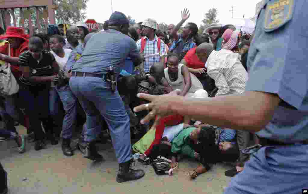 South African police control the crowd following a crush as people jostled to see former South African president Nelson Mandela on the last day of his lying in state in Pretoria, Dec. 13, 2013. 