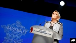 FILE - French far-right leader Marine Le Pen gestures as she delivers a speech to announce a name-change for her National Front party, in Bron, central France, June 1, 2018.