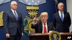 FILE - President Donald Trump, center, signed two executive actions at the Pentagon in Washington, Jan. 27, 2017, with Vice President Mike Pence, left, and Defense Secretary James Mattis at his side.
