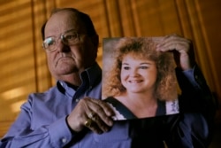 Brian Simmons, pemilik rumah duka, menunjukkan foto putrinya, Rhonda Ketchum, yang meninggal karena COVID-19 menjelang Natal, di Springfield, 28 Januari 2021. (Foto: AP)
