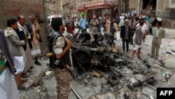 Yemenis surround the wreckage of a vehicle outside the Kobbat al-Mehdi Shi'ite mosque after a car bomb targeting the area killed two people in the capital Sana'a, June 20, 2015.