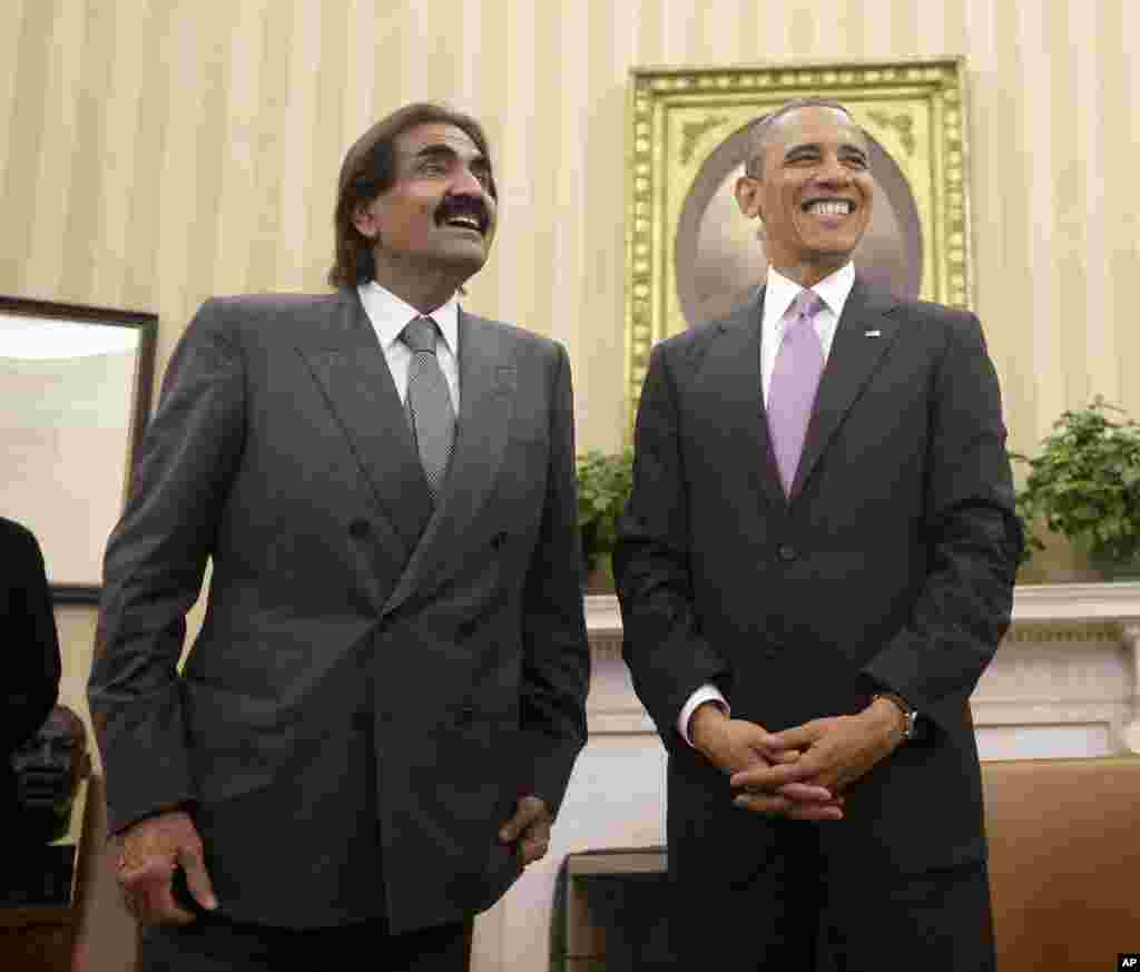 President Barack Obama stands with Sheik Hamad bin Khalifa Al Thani of Qatar following their meeting in the Oval Office of the White House in Washington, April 23, 2013.