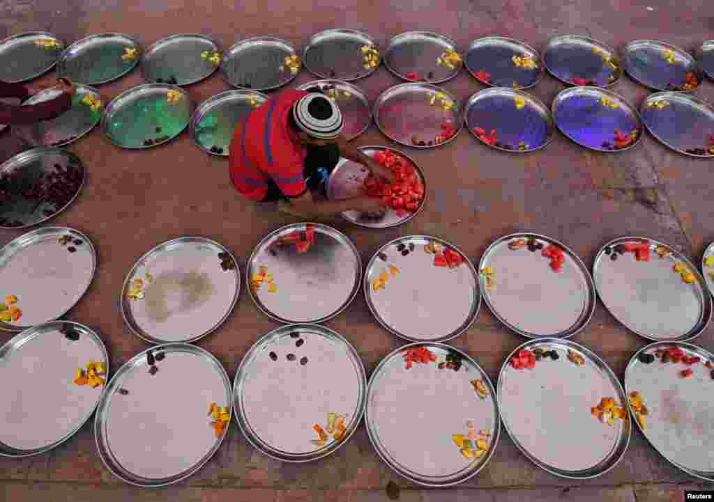 A Muslim man prepares plates of food for Iftar (breaking fast) meals inside a mosque during the holy month of Ramadan in Ahmedabad, India, June 10, 2018.