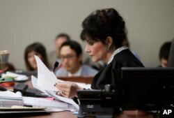 Judge Rosemarie Aquilina reads excerpts from the letter written by Larry Nassar during the seventh day of Nassar's sentencing hearing, Jan. 24, 2018, in Lansing, Mich. The former sports doctor who admitted molesting some of the nation's top gymnasts for y