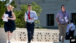 In this file photo, new interns run with a decision across the plaza of the U.S. Supreme Court in Washington, June 29, 2015. (Photo by Jacquelyn Martin/AP)