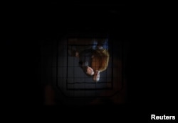 Rute Magalhaes, 33, and Filipe Alves, 38, are seen through a large format camera while they pose for a portrait at their studio in Lisbon, Portugal, Feb. 8, 2018.