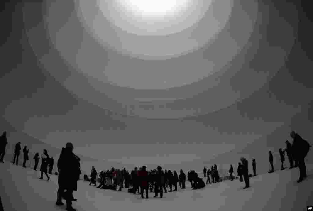 Visitors walk around inside the installation 'Big Air Package' during the unveiling at the Gasometer in Oberhausen, Germany. Bulgarian aritst Christo's latest monumental sculpture is in the interior of the industrial monument.