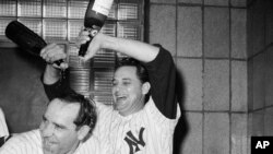 New York Yankees manager Yogi Berra gets a champagne shampoo from Pete Ramos after the Yanks clinched the American League Pennant by defeating Cleveland, 8-3, Oct. 3, 1964.