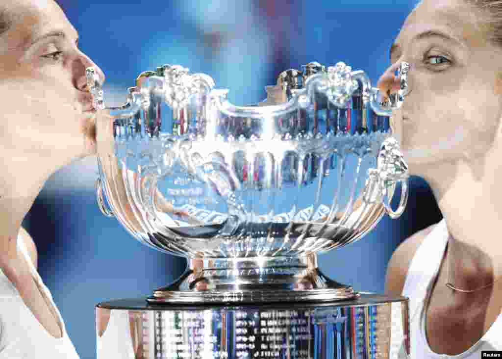 Sara Errani (R) and Roberta Vinci of Italy kiss their trophy after defeating Ashleigh Barty and Casey Dellacqua of Australia in their women’s doubles final match at the Australian Open tennis tournament in Melbourne.