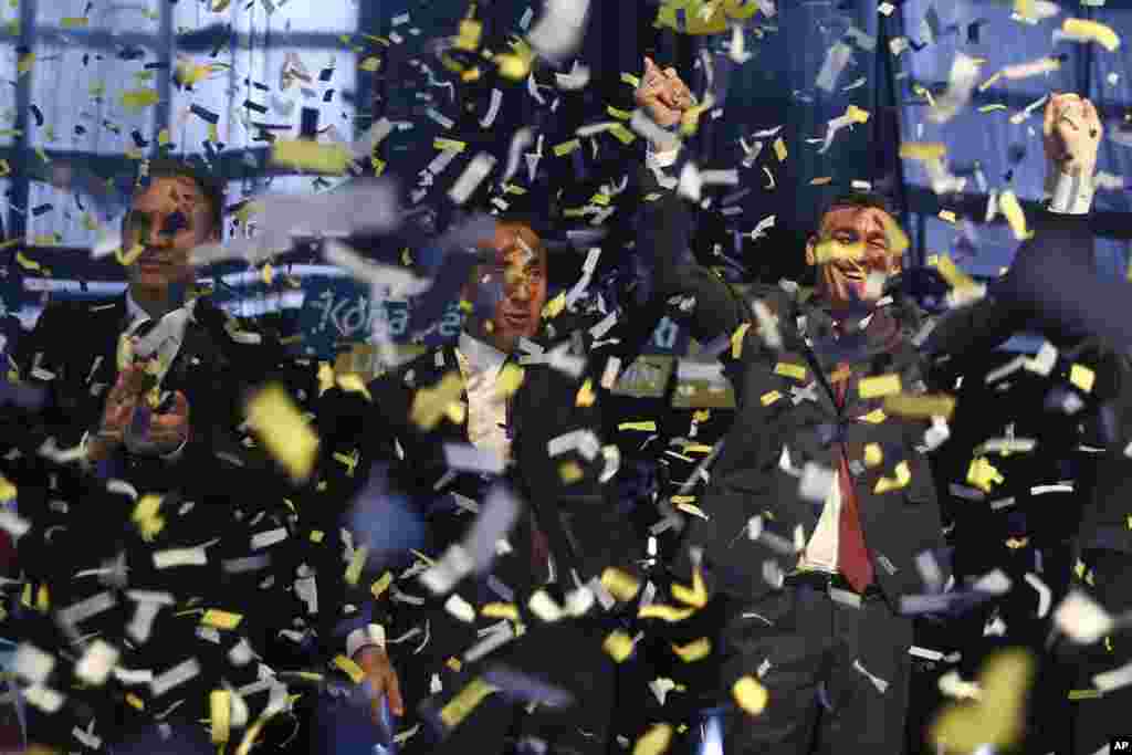 Ramush Haradinaj, tengah, pemimpin Aliansi untuk Masa Depan Kosovo (AAK), kandidat pemelihan PM dari koalisi PAN (PDK, AAK, NISMA), didampingi oleh Kadri Vaseli, kanan, pemimpin Partai Demokratik Kosovo (PDK), dan Fatmir Limaj, pemimpin NISMA, saling berpegangan tangan dalam sebuah tanda kemenangan selama penutupan kampanye pemilu di ibukota Kosovo, Pristina.