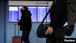 FILE - Travelers walk through O'Hare International Airport ahead of the Thanksgiving holiday in Chicago, Illinois, Nov. 20, 2021. 