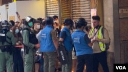 香港警方6月28日下午在旺角登打士街展開大圍捕，傳媒聯絡隊人員檢查採訪期間被封鎖線圍困記者的證件才放行。(美國之音湯惠芸)