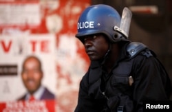 Police stand guard during a raid on the headquarters of the opposition Movement for Democratic Change (MDC) a day after post-election clashes between security forces and opposition protesters in Harare, Zimbabwe, Aug. 2, 2018.