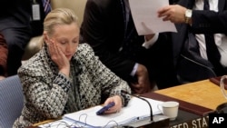 In this March 12, 2012, file photo, then-Secretary of State Hillary Clinton checks her mobile phone after her address to the Security Council at United Nations headquarters.