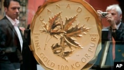 Visitors take a look at the world's biggest and most expensive gold coin, the "Canadian Maple Leaf", on Wednesday, May 28, 2008, at Vienna's art history museum. A similar coin was stolen in Berlin this week.