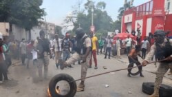 Polisi tampak berusaha memindahkan ban yang terbakar saat berlangsungnya unjuk rasa di Port-au-Prince pada 18 Oktober 2021 yang memprotes maraknya kasus penculikan di Haiti. (Foto: Reuters/Ralph Tedy Erol)