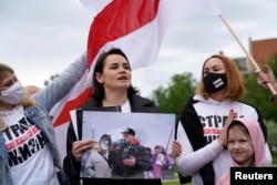 FILE - Belarus opposition leader Sviatlana Tsikhanouskaya holds a picture of her husband Syarhei Tsikhanouski during a "Belarus support day" protest in Vilnius, Lithuania, May 29, 2021.