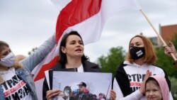 Pemimpin oposisi Belarus Sviatlana Tsikhanouskaya memegang foto sang suami, Syarhei Tsikhanouski, dalam aksi protes di Vilnius, Lithuania, pada 29 Mei 2021. (Foto: Reuters)