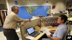National Hurricane Center director Bill Read, left, talks with meteorologist Wallace Hogsett, Monday, Aug. 22, 2011 at the National Hurricane Center in Miami.