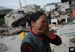 Reaksi seorang perempuan desa setelah rumahnya rusak akibat gempa di Kabupaten Lushan, Ya'an, Provinsi Sichuan, China barat daya pada Sabtu, 20 April 2013. (Foto: AP)