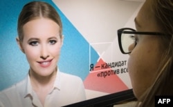 FILE - A journalist looks at a computer screen displaying Ksenia Sobchak's campaign web page, in Moscow, Russia, Oct. 19, 2017.