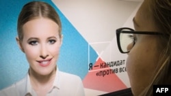 A journalist looks at a computer screen displaying Ksenia Sobchak's campaign web page, in Moscow, Russia, Oct. 19, 2017.