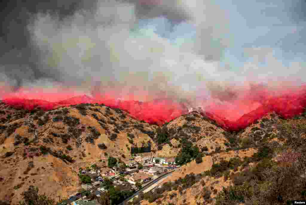 Retardant, dropped by a plane, drifts down on flames at the La Tuna Canyon fire in Burbank, California, Sept. 2, 2017.