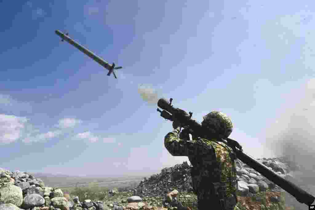 A Kyrgyzstan&#39;s soldier shoots from a portable air-defense system during a joint military exercises at the Edelweiss training ground, about 180 kilometers (113 miles) southeast of Bishkek.