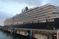 អ្នកដំណើរតាមនាវា Westerdam រង់ចាំមើលការមកដល់របស់លោកនាយករដ្ឋមន្រ្តី ហ៊ុន សែន និងការឡើងគោករបស់អ្នកធ្វើដំណើរមួយចំនួន កាលពីព្រឹកថ្ងៃសុក្រ នៅខេត្តព្រះសីហនុ។ (ស៊ុន ណារិន/VOA)