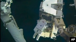 In this still image taken from video provided by NASA, astronaut Peggy Whitson takes a spacewalk outside the International Space Station on Friday, Jan. 6, 2016. 