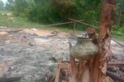 In this image provided by Myanmar Witness, which is undated and unverified but matches AP reporting and eyewitness testimony, a burned structure with household goods is seen outside Taung Pauk village in Kani township in Myanmar's Sagaing region.