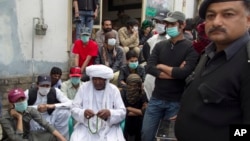 Mama Qadeer Baluch, wearing a white turban, chairman of the Voice for Baluch Missing Persons, waits to start a march with protesters in Rawalpindi, Pakistan, Feb. 27, 2014.