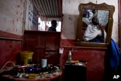 Peter Jean-Baptiste, gets a haircut and a shave in the barbershop of his brother Phillippe Jean-Baptiste in Canaan, June 21, 2015.