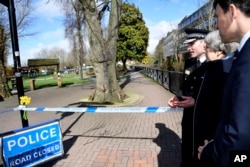 FILE - Britain's Prime Minister Theresa May is accompanied by Wiltshire Police Chief Constable Kier Pritchard and Salisbury MP John Glen, as she views the area where former Russian double agent Sergei Skripal and his daughter were found critically ill, in Salisbury, Britain.