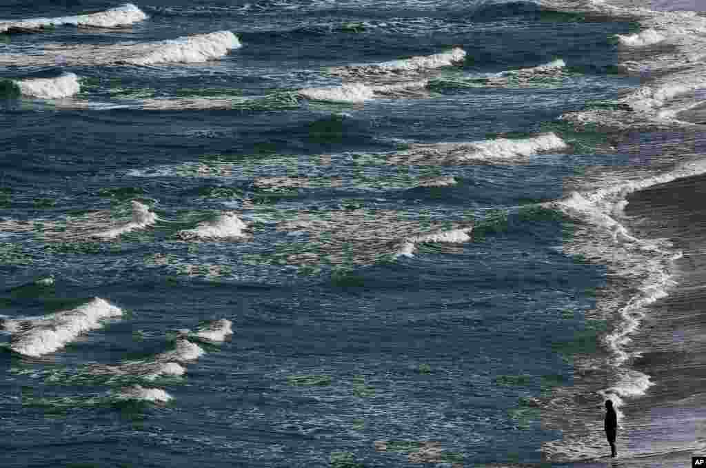 A man walks on the beach in Biarritz, southwestern France.