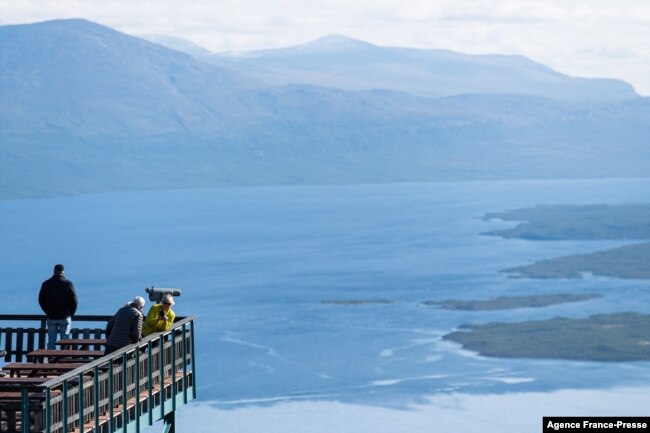 FILE - Tourists visit Mount Nuolja overlooking Abisko in northern Sweden on Aug. 26, 2021, where scientists and researchers are investigating the impact on climate change on many aspects of the Arctic.