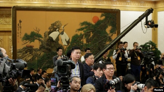 各国记者在等待中国国家主席习近平和其他中共中央政治局常委到达北京人大会堂。（2017年10月25日）