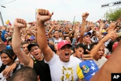 Supporters of Venezuela's National Assembly President and self-proclaimed interim president of Venezuela, Juan Guaido, cheer during his rally on the shores of Maracaibo Lake in Cabimas, Venezuela, April 14, 2019.