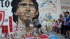 Warga Argentina berduka cita atas meninggalnya legenda sepakbola Diego Armando Maradona, di luar stadion Diego Armando Maradona di Buenos Aires, Argentina Rabu (25/11). 