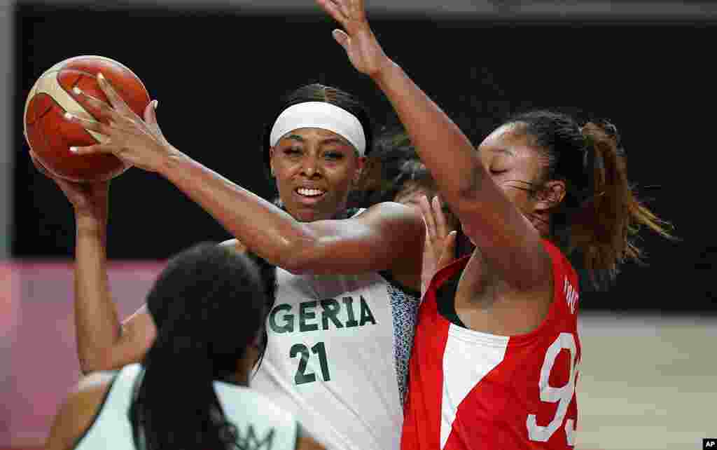 Nigeria&#39;s Atonye Nyingifa (21) passes around Japan&#39;s Monica Okoye (99), right, during women&#39;s basketball preliminary round game at the 2020 Summer Olympics, Monday, Aug. 2, 2021, in Saitama, Japan. (AP Photo/Charlie Neibergall)