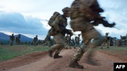 Des soldats lors d'un exercice militaire simulé de l'unité d'entraînement des Forces de défense du Kenya au ranch ol-Daiga, haut sur le plateau de Laikipia au Kenya, le 26 mars 2018.