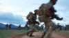 Des soldats traversent une route lors d'un exercice militaire simulé de l'unité d'entraînement de l'armée britannique au Kenya (BATUK) avec les Forces de défense du Kenya (KDF) au ranch ol-Daiga, haut sur le plateau de Laikipia au Kenya, le 26 mars 2018.