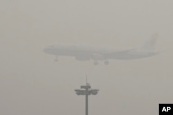 FILE - An Air China passenger plane prepares to land at the Beijing Capital International Airport as the capital of China through heavy smog, Dec. 21, 2016.