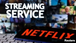 A smartphone with the Netflix logo is seen on a keyboard in front of displayed "Streaming service" words in this illustration taken March 24, 2020. REUTERS/Dado Ruvic