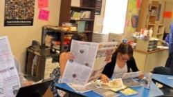 Little Wound journalism class students check their published work.